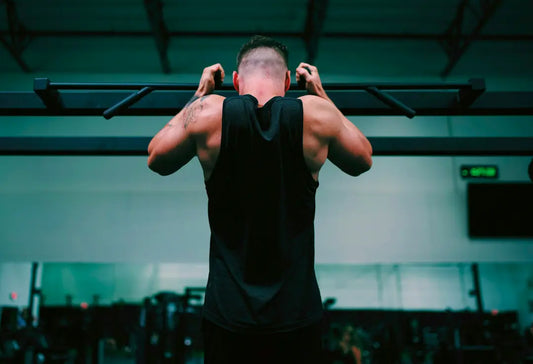 Sportlicher Mann beim Training (Rückansicht); glänzende Haut als Sinnbild für Power, Schweißbildung und die Notwendigkeit funktionaler Unterwäsche