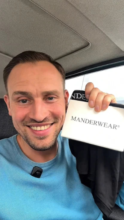 MANDERWEAR® ergonomische Herrenunterwäsche mit Pouch-Design gegen Hautreibung, Kleben und Zwicken. Abbildung einer Verpackung gehalten von einem Mann. 