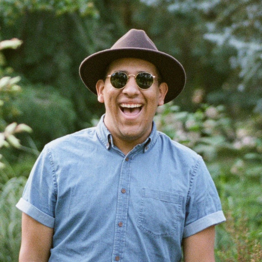 files/a-man-in-a-fedora-and-sunglasses-beams-in-the-woods.jpg